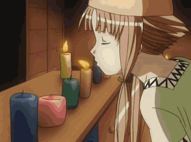a girl is looking at a row of lit candles on a table