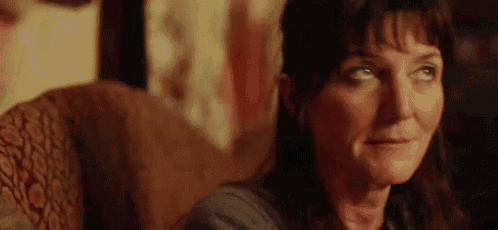 a woman is sitting in a chair with her eyes closed and looking at the camera .