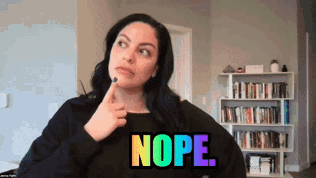 a woman in a black sweater with the word nope written on it