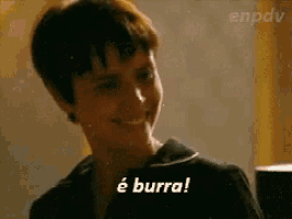 a woman with short hair is smiling and says e burra .