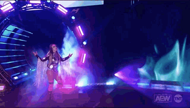 a woman is standing on a stage with a sign that says aew on it .