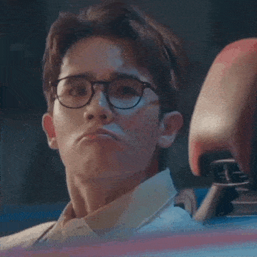 a man wearing glasses makes a funny face