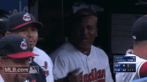 a group of indians baseball players standing in a dugout during a game