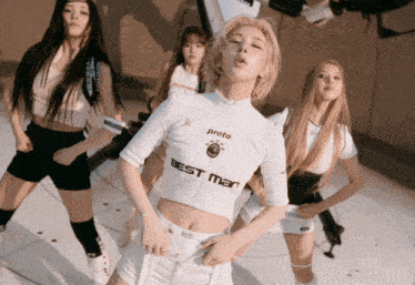 a woman in a proto best man shirt is dancing with other women