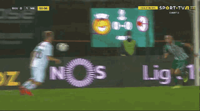 a soccer game is being played in front of an advertisement for nos