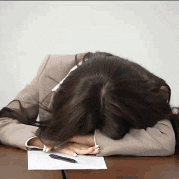 a woman rests her head on a piece of paper