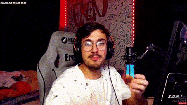 a man wearing glasses and headphones is sitting in front of a z.o.r.t sign