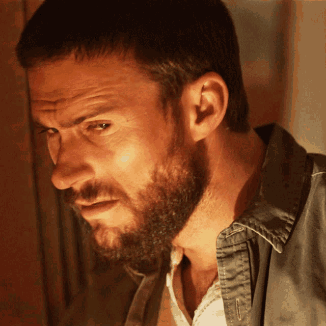 a man with a beard is wearing a jacket