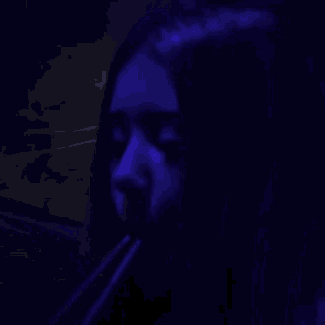 a blue light is shining on a blue background and smoke is coming out of a pipe .
