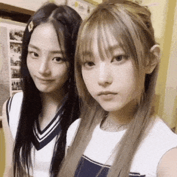 two girls are posing for a picture in front of a sign that says salle