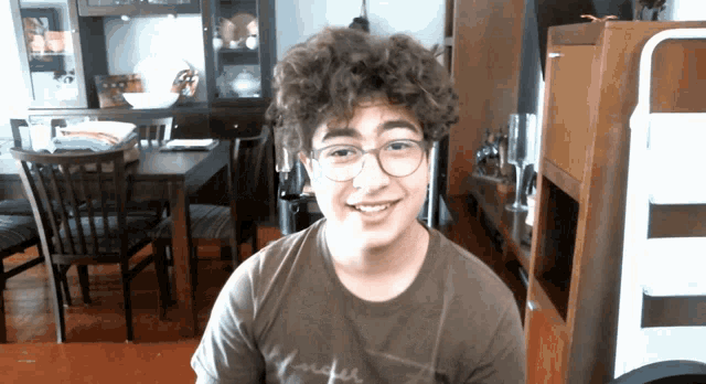 a young man wearing glasses and a t-shirt with the word rider on it