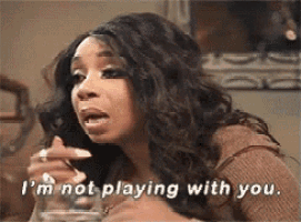 a woman is sitting at a table with a glass of water and saying `` i 'm not playing with you '' .