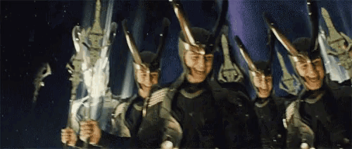a group of men wearing helmets and holding swords in a dark room