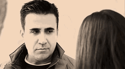 a man and a woman are looking at each other and talking .