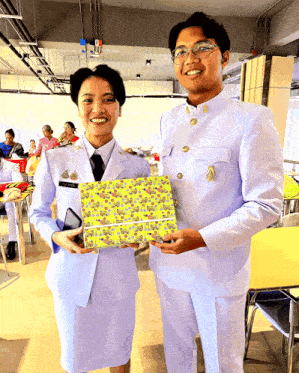 a man and a woman in white uniforms are holding a box
