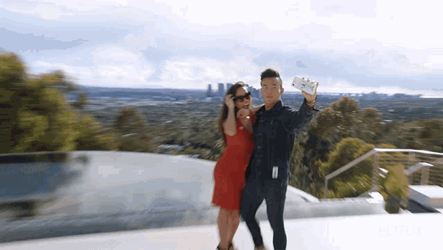 a man and a woman are taking a selfie with a netflix logo behind them