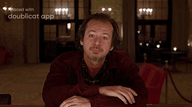 a man is sitting at a table with his mouth open and the words faced with doublecat app behind him