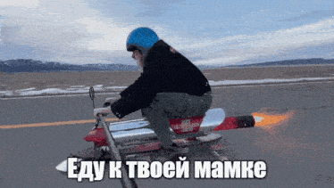 a man in a blue helmet is riding a red motorcycle with a flame coming out of the back
