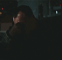 a man is sitting in a dark room looking at the camera .