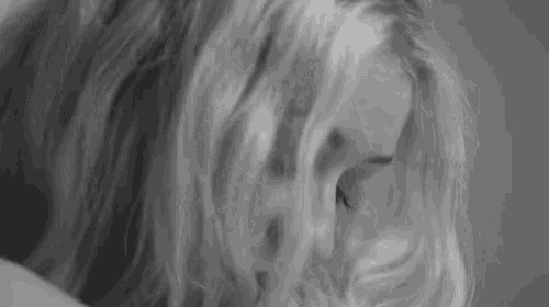 a black and white photo of a woman 's face and hair .
