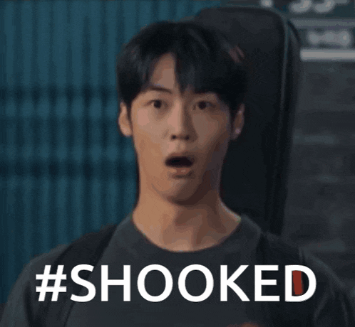 a man with a surprised look on his face is holding a guitar case and the word shooked is on the screen .