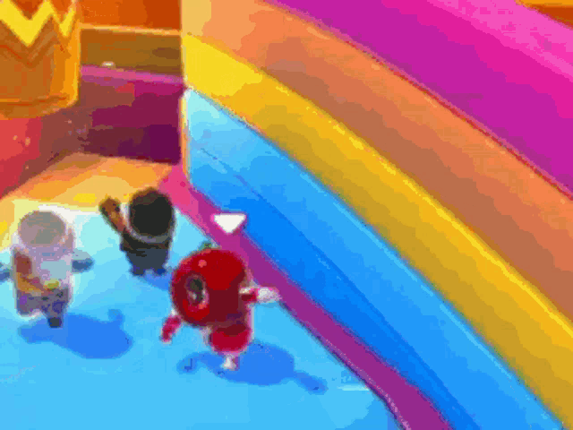 a group of cartoon characters are standing next to each other in front of a colorful inflatable slide .