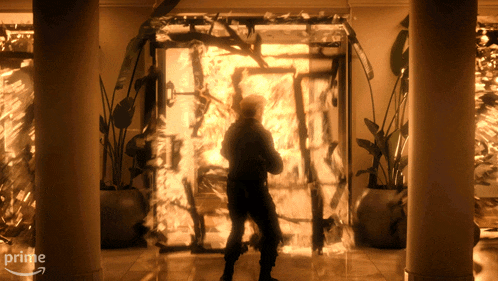 a man is standing in front of a door that is on fire and says prime on the bottom