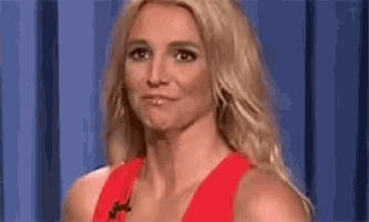a close up of a woman in a red dress making a funny face .