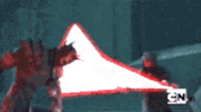 a blurry picture of a person holding a red triangle with the letters tn on it