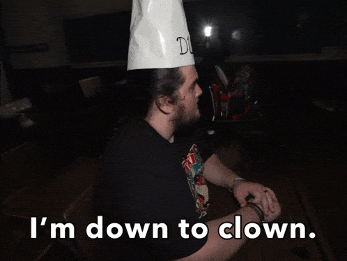 a man with a beard wearing a paper hat that says duno