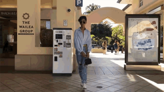 a person walking in front of a building that says the wailea group