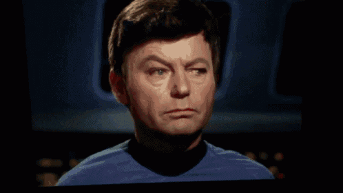a man in a red sweater is standing next to another man in a blue shirt