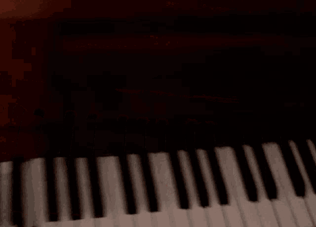 a person playing a piano with their hands on the keys