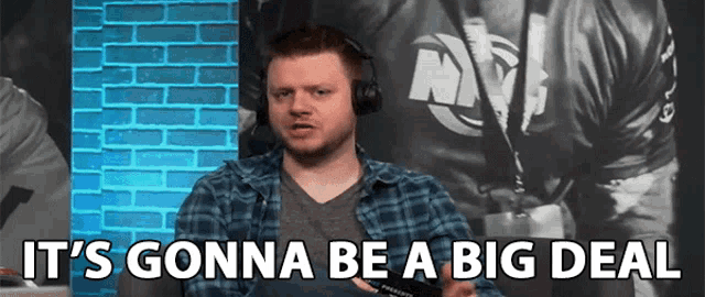 a man wearing headphones says it 's gonna be a big deal in front of a brick wall