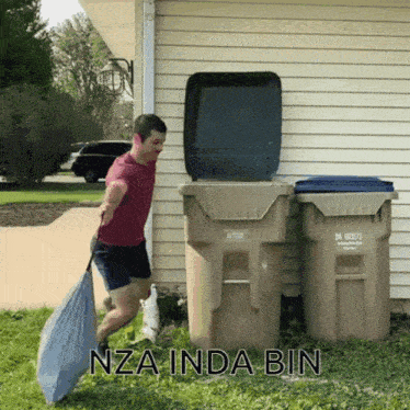 a man is pushing a garbage can with the words nza inda bin written on the bottom