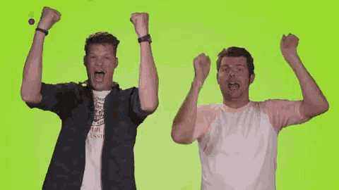 two men are raising their arms in the air .