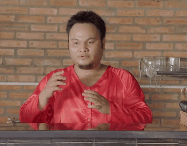 a man in a red shirt is sitting at a table