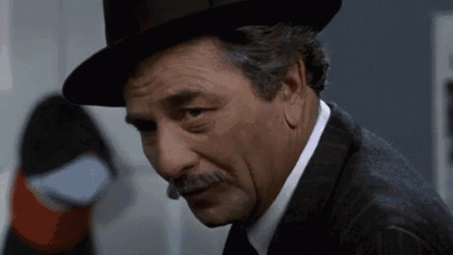 a man with a hat and mustache is looking down