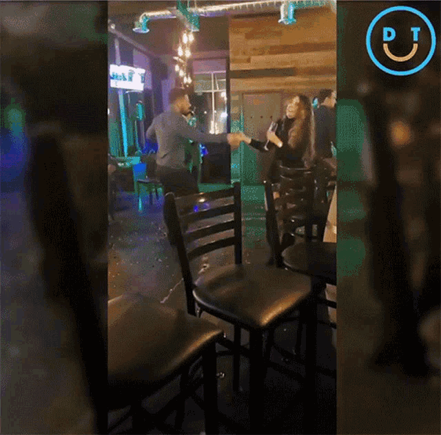 a man and woman are dancing in a room with a pt logo on the bottom