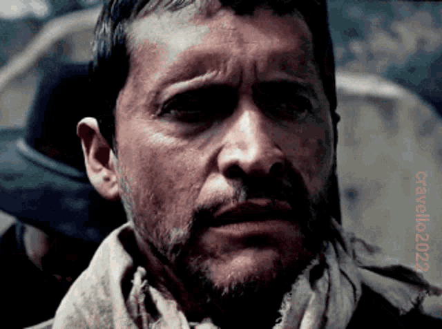 a close up of a man 's face with a scarf around his neck and the words " cravello24 " on the bottom