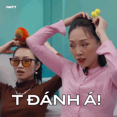 a woman in a pink shirt has a yellow rubber duck on her head and the words t danh a