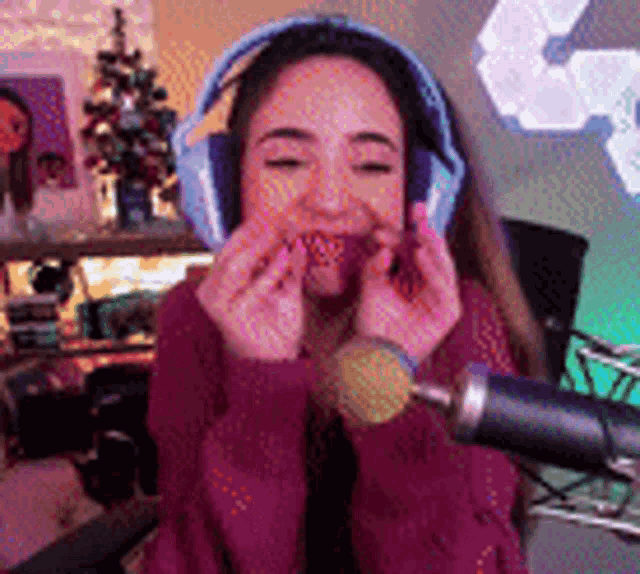 a woman wearing headphones and a microphone is eating a strawberry .