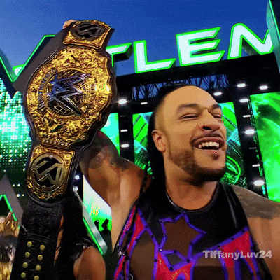 a man holding a wrestling championship belt in front of a sign that says ' wlen '