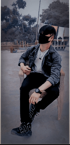 a man wearing a mask sits in a chair