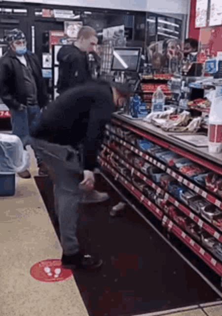 a man wearing a mask is standing in a store looking at something .