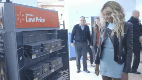 a woman in a blue dress stands in front of a display that says low price