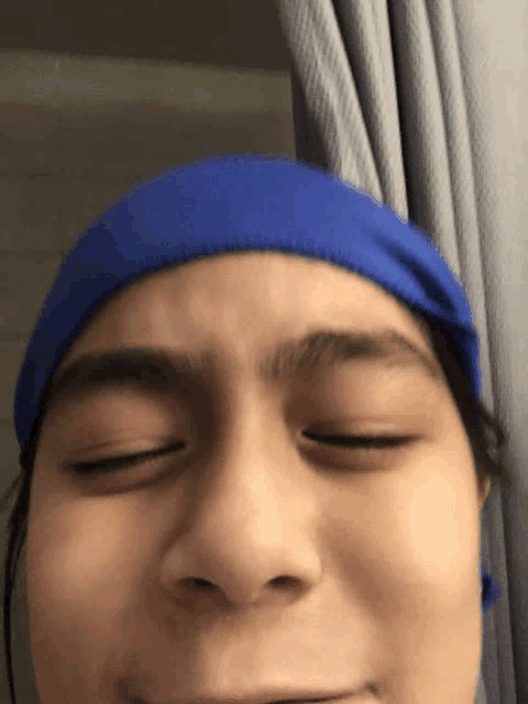 a close up of a person 's face with a blue headband on