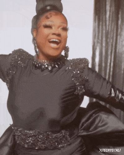 a woman in a black dress and gloves is smiling and dancing .