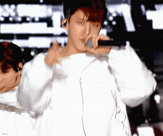 a man in a white shirt is holding a microphone