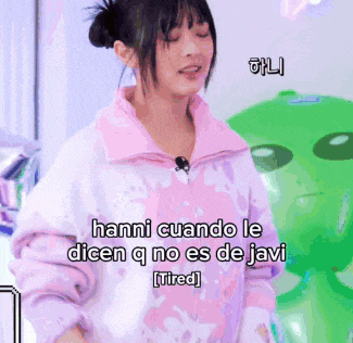 a woman in a pink jacket says " hanni cuando le dicen q no es de javi [tired] "